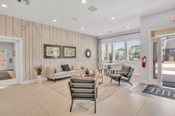 clubhouse with a couch and chairs and a table at spire apartments