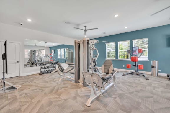 Fitness center with weights and cardio equipment at Spire Apartments