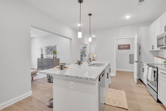a kitchen with a large island and a stainless steel refrigerator at spire apartments