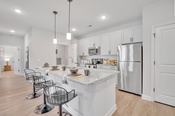 a kitchen with marble counter tops and white cabinets at spire apartments in charlotte, nc