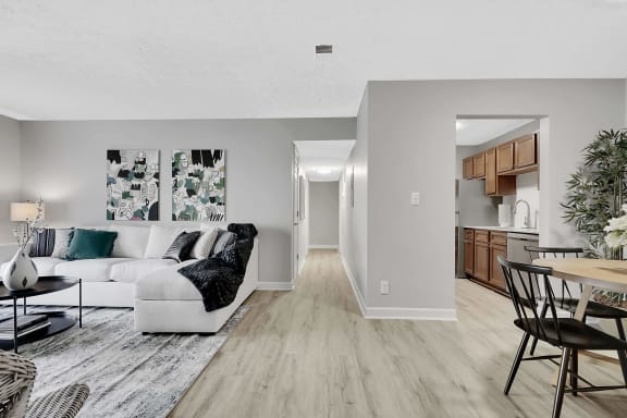 a living and dining room area with a white couch and a wooden table