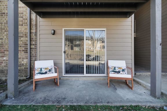 two chairs sit on a patio in front of a door at Stonewater Apartments, Louisville, KY