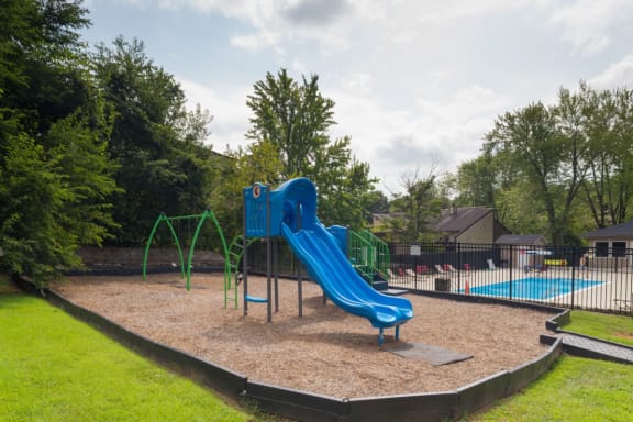 a playground with a blue slide in a park at Stonewater Apartments, Louisville, KY