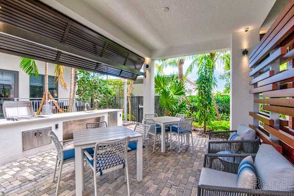 A patio with a table and chairs is covered by a roof at Mayla Pompano, Pompano Beach, 33062