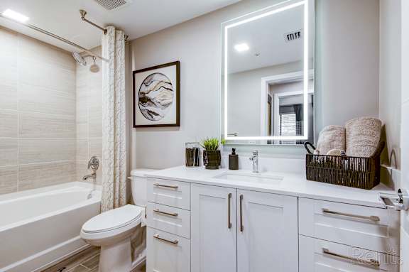 A white bathroom with a toilet, sink, and bathtub.