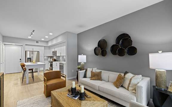A modern living room with a white couch and a wooden coffee table.