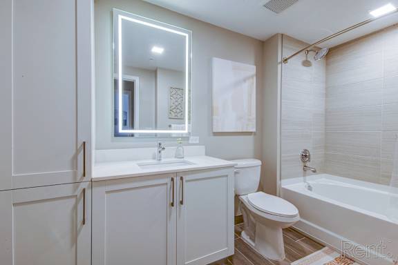 A white bathroom with a toilet, sink, and bathtub.
