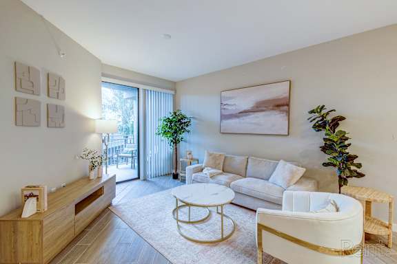 A living room with a white couch, a coffee table, and a large painting on the wall.