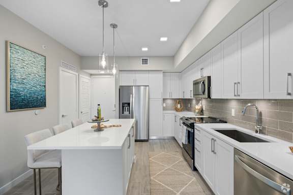 A modern kitchen with white cabinets and a large island.