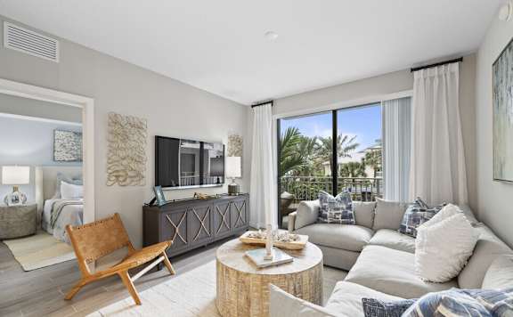 A living room with a wooden chair and a grey couch.