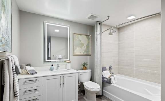 A bathroom with a white tub, sink, and toilet.