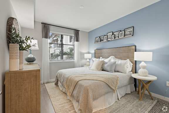 A bedroom with a large bed and a wooden headboard.