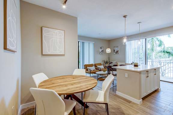 A dining room with a wooden table and chairs.