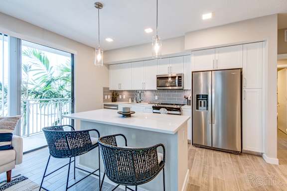 A kitchen with a white countertop and stainless steel appliances.