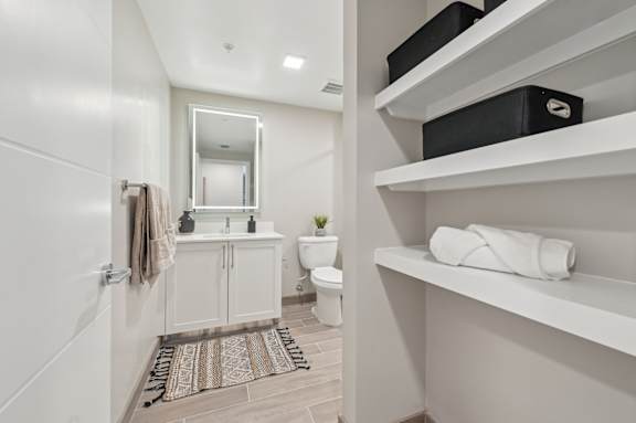 A bathroom with a toilet, sink, and mirror.