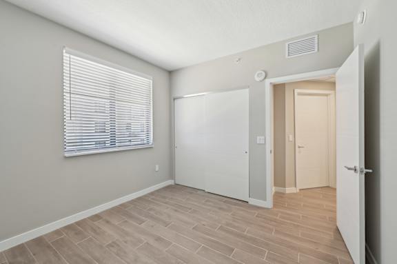 A room with a white door and a window with blinds.