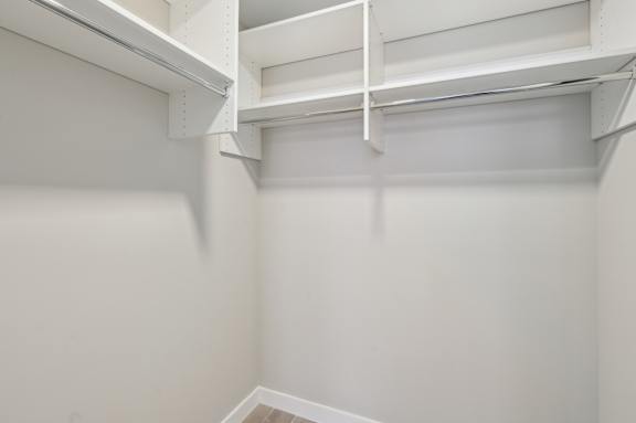 A white empty room with a shelf on the wall.
