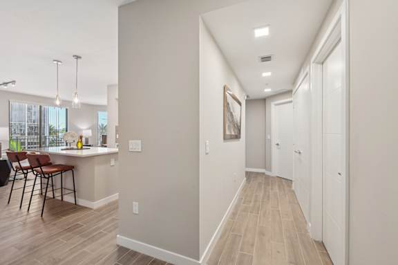 A long hallway with a white door at the end.