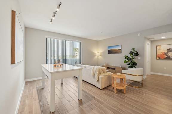 A living room with a white couch, a wooden coffee table, and a plant.