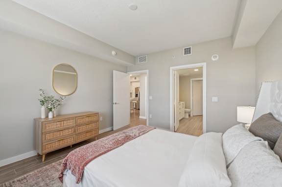 A bedroom with a bed, dresser, and mirror.