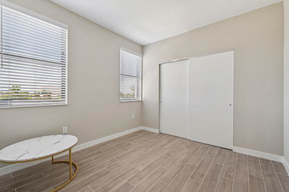 A room with a white table and a white closet.