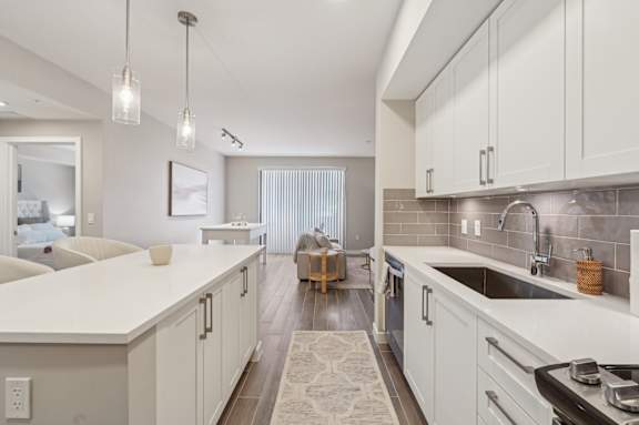 A modern kitchen with white cabinets and a large island.