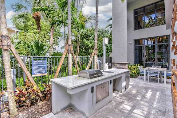 A concrete desk with a chair and a signboard in the background at Mayla Pompano, Pompano Beach, Florida