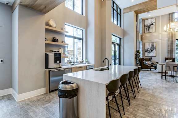 A modern kitchen with a large island and stainless steel appliances at Mayla Pompano, Pompano Beach, Florida
