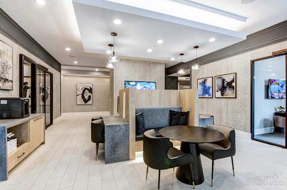 A modern living room with a grey sofa, a round table and a television at Mayla Pompano, Pompano Beach, FL