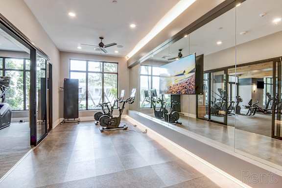 A spacious room with a treadmill and a television at Mayla Pompano, Pompano Beach, 33062