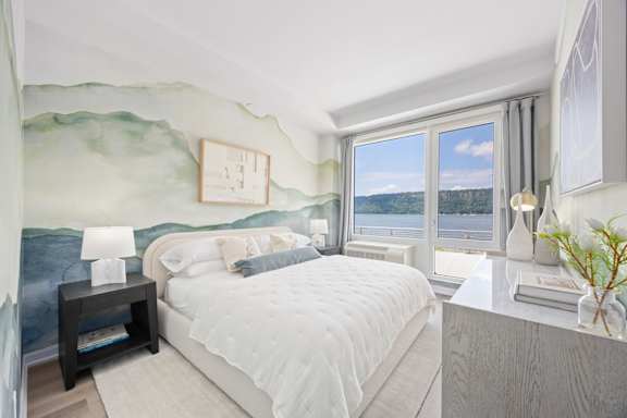 A bedroom with a large bed and a painting on the wall.