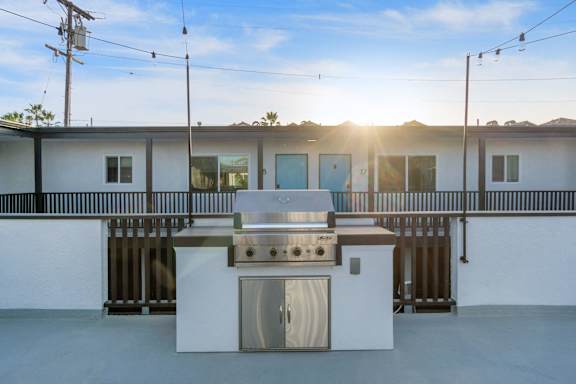 A white outdoor kitchen with a grill and sink at Ocean Breeze Terrace Apartment, Huntington Beach, 92648