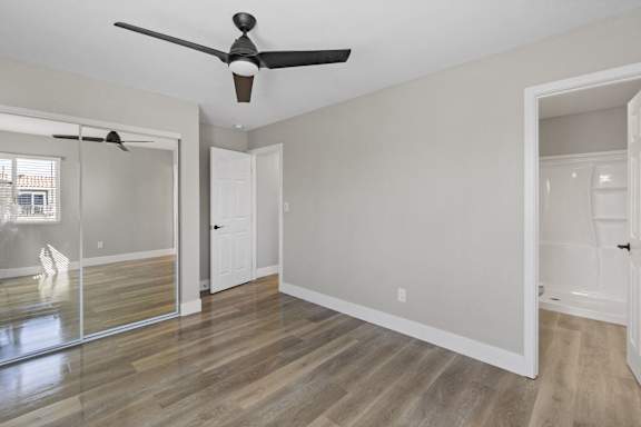 an empty living room with a ceiling fan and a mirrored closet at Ocean Breeze Terrace Apartment, California, 92648