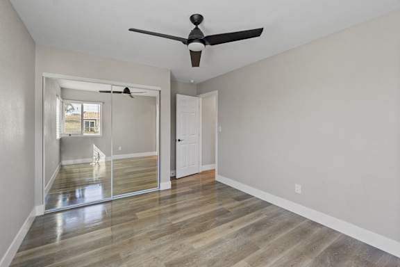 an empty living room with a ceiling fan at Ocean Breeze Terrace Apartment, Huntington Beach, CA