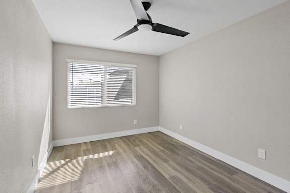 an empty room with wood flooring and a ceiling fan at Ocean Breeze Terrace Apartment, Huntington Beach, CA, 92648