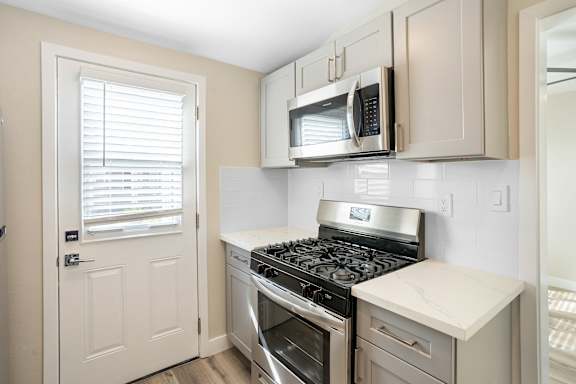 an empty kitchen with a stove and a microwave