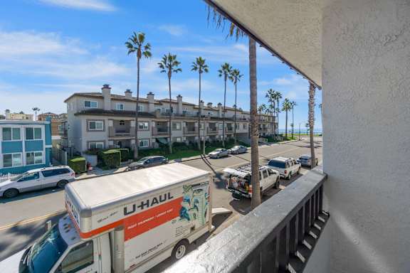 a view of a parking lot with cars and palm trees at Ocean Breeze Terrace Apartment, California, 92648