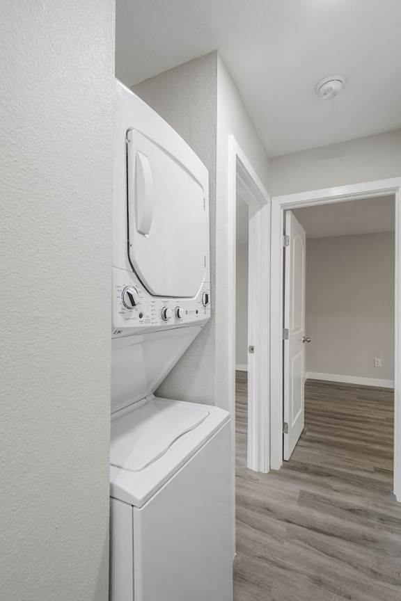 a laundry room with a washer and dryer and a hallway to a door