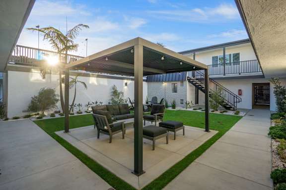A patio with a table and chairs under a roof at Ocean Breeze Terrace Apartment, Huntington Beach, California