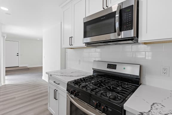 a kitchen with white cabinets and stainless steel appliances
