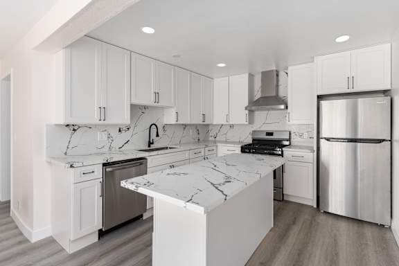 a kitchen with white cabinets and white marble countertops at Seaview Terrace in San Clemente, CA