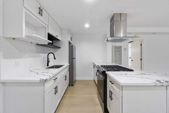 A white kitchen with a black stove top oven. at Torrance Gateway Apartments, Torrance, 90501