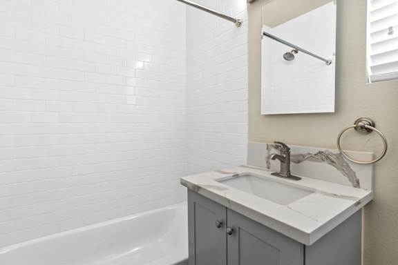 a bathroom with a sink and a tub and a mirror