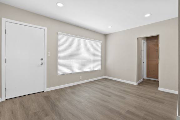 an empty room with a door to a closet and a window