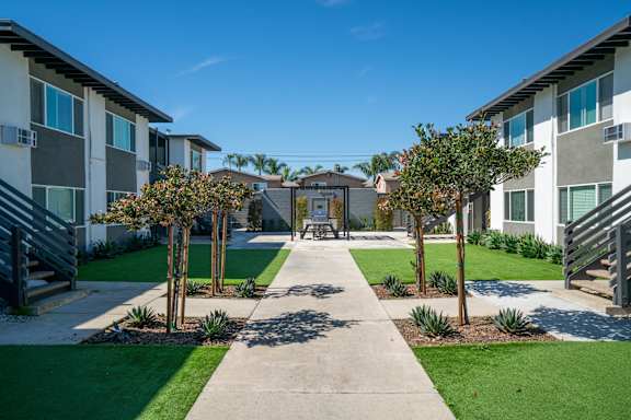 A sunny day at a residential area with apartment buildings and a walking path.