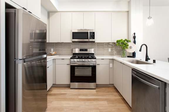 A modern kitchen with stainless steel appliances and white cabinets. at The Reserve La Mirada, La Mirada, California