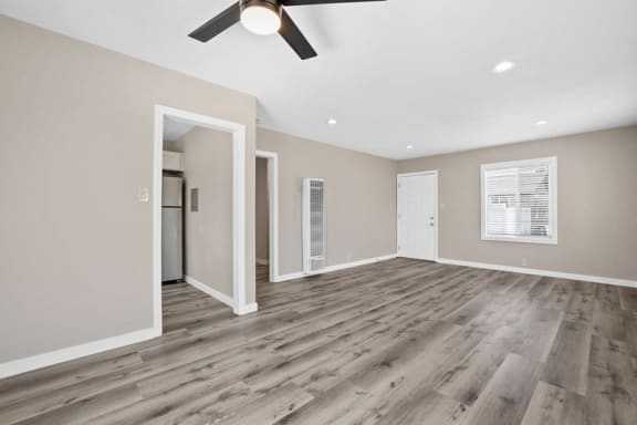 an empty living room with a ceiling fan