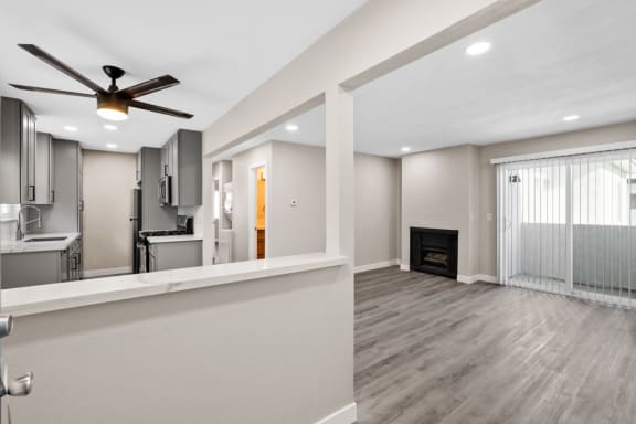 A modern living room with a fireplace, ceiling fan, and balcony at 316 Beach Apartments