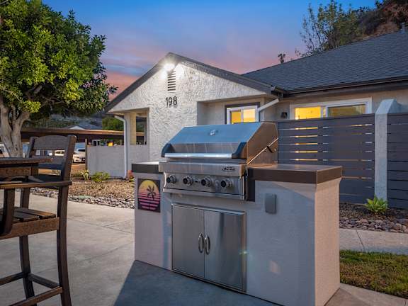 A modern outdoor kitchen with a grill and a table.