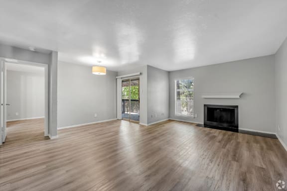 A spacious living room with a fireplace and sliding glass doors.